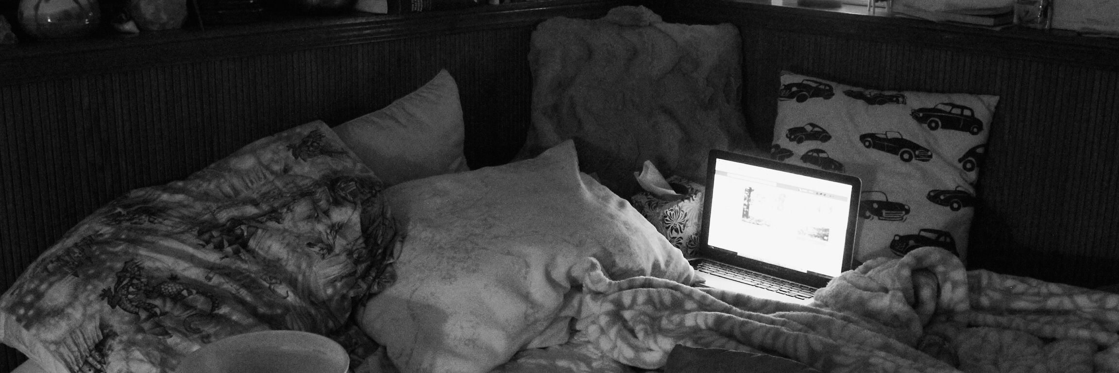 Why I See My Severe Insomnia as a Blessing and a Curse bedroom in darkness with laptop on bed and salt lamp on shelf