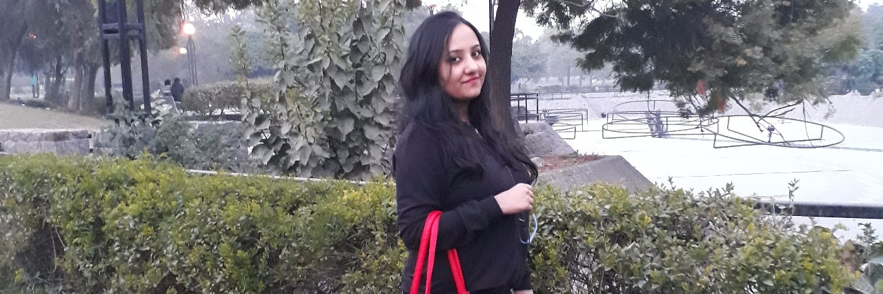 Why People Shouldn't Judge My Illness Based on Social Media Photos girl holding red bag standing under tree on lawn