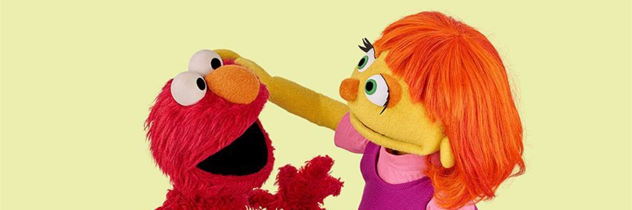 Why I Will Be Watching 'Sesame Street' as an Adult Julia and Elmos sitting down, Julia is patting Elmo's head