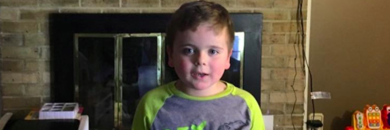 How My Son on the Autism Spectrum Is Using His Voice in His Own Way Boy standing in living room in front of TV with the movie "Finding Dory" on