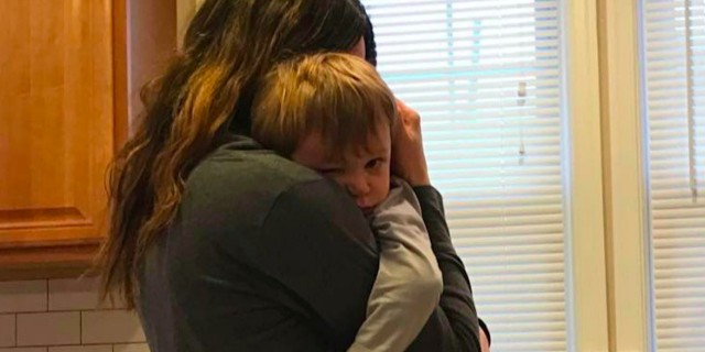 A Letter of Love to My Son With Hydrocephalus Mom holding baby son while standing in kitchen near sink