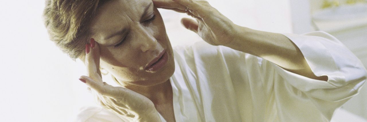 My Journey to Being Diagnosed With a Spinal CSF Leak Woman holding the side of her head in pain