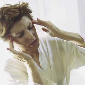 Woman holding the side of her head in pain