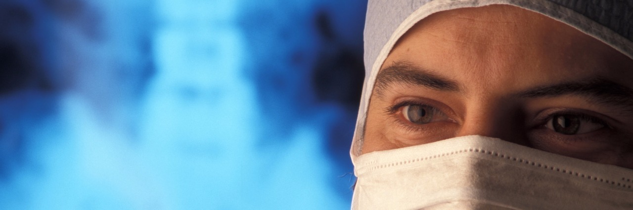 Why I Prefer Doctors Who Admit, 'I Don't Know' dotor with a surgical mask standing in front of x ray