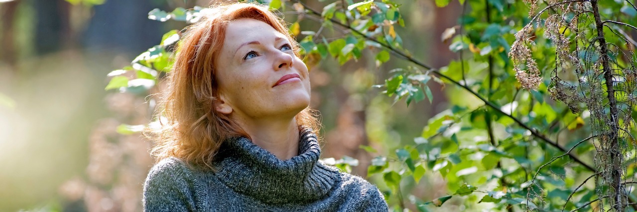 Ehlers-Danlos, Hashimoto's, ME/CFS:Positive Effects of Chronic Illness woman standing outside next to bushes and smiling at sunshine