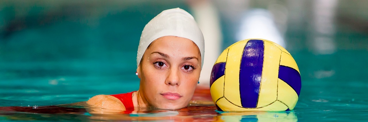 Young woman playing water polo in the pool