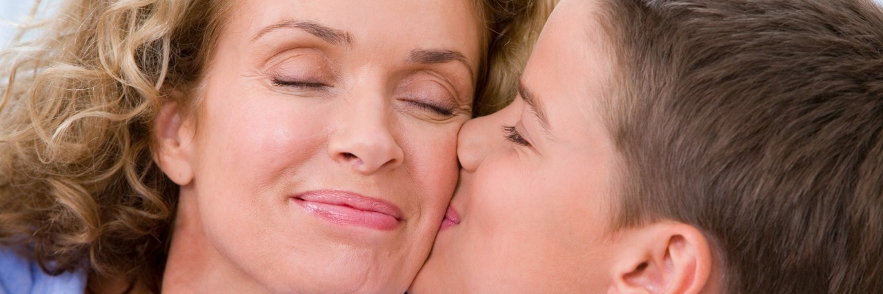 The Guilt I Feel Watching My Child Take Care Of Me son kissing mom