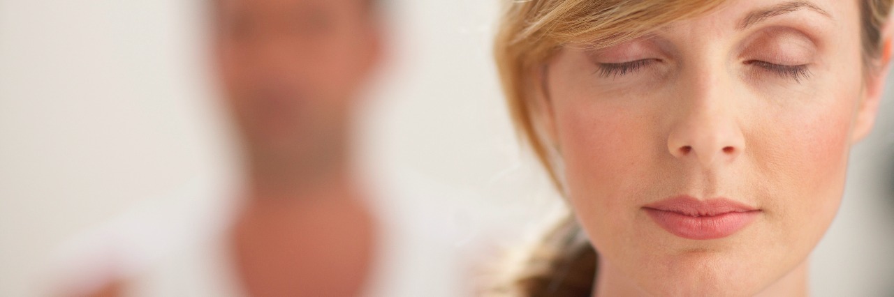 How Meditation Has Helped Me After My Partner's Suicide Woman with eyes closed, close-up, man in background