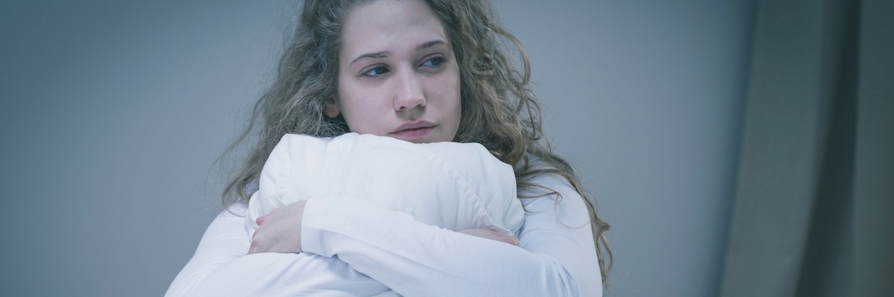 Why I Can't 'Just Do It' Because of My Mental and Physical Illness Woman holding a pillow