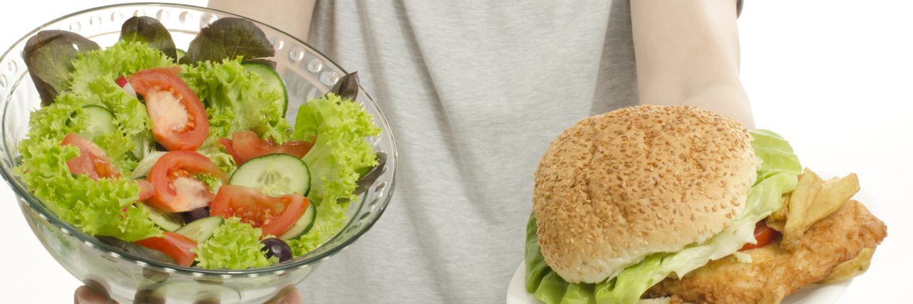 Man hands offering you salad and a hamburger