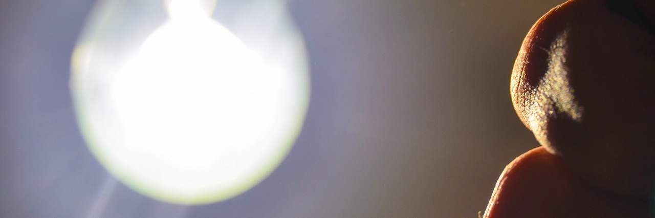 Why My Brain Fog Feels Like a Light Switch hand turning off lightbulb