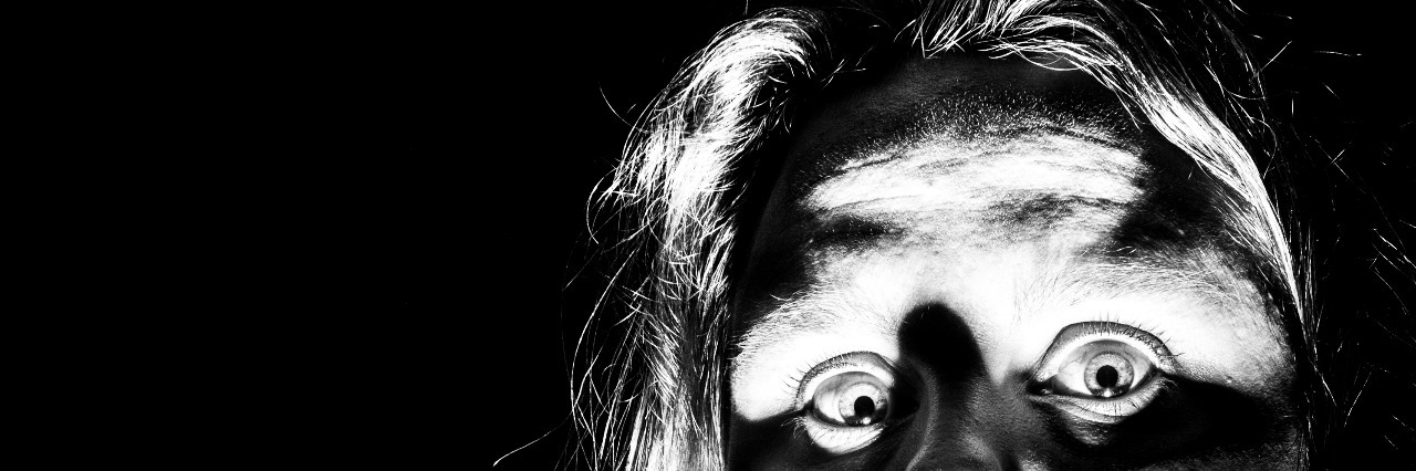 The Horror Movie of My Anxiety and Depression A woman peeks out from the corner of a picture as if she is checking to see if it is safe to come out.