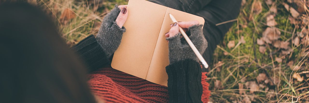 Why I Write About Mental Illness Woman writing in her note book