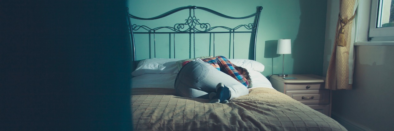 What It's Like Having to Stay in Bed for Chronic Pain Sad woman is lying on a bed