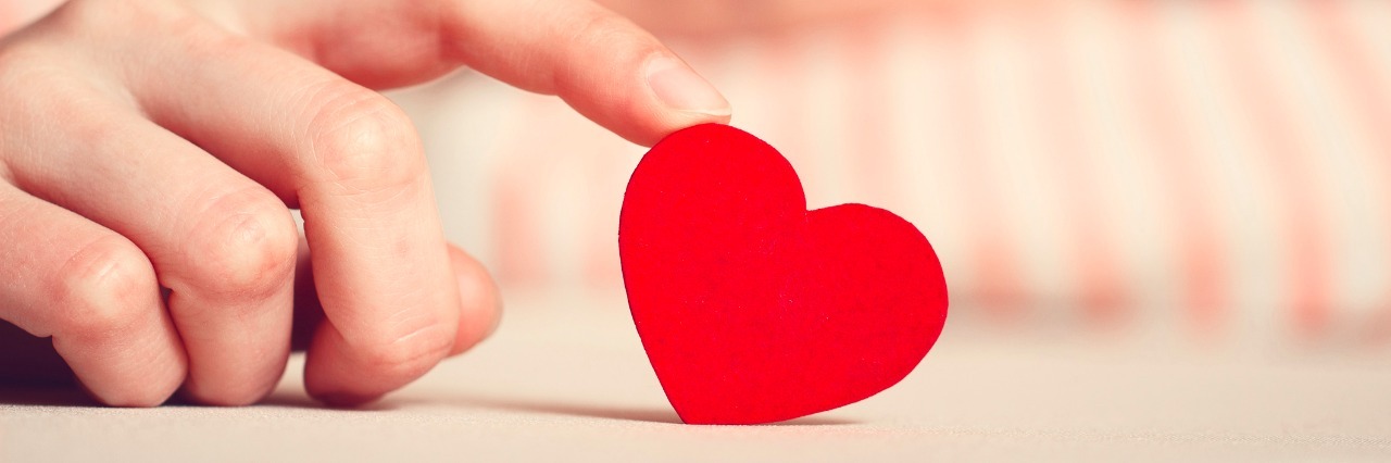 Learning to Accept That I Am Worthy When I Feel Anything but OK Sad girl is holding heart symbol by her finger