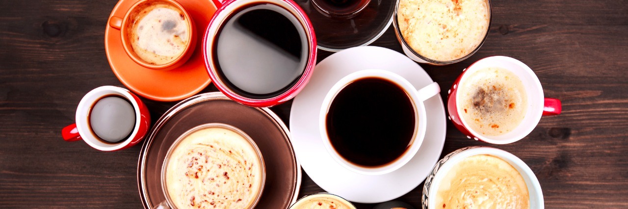 Please Don't Suggest 'More Coffee' for My Chronic Fatigue Many different cups of coffee on dark wooden table, top view.