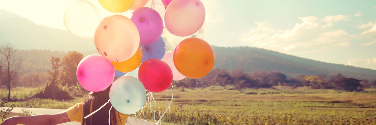 World Bipolar Day: What Does Bipolar Disorder Fuel Your Passion For? Woman walking down the road holding a balloon