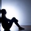 silhouette of person sitting on floor against wall