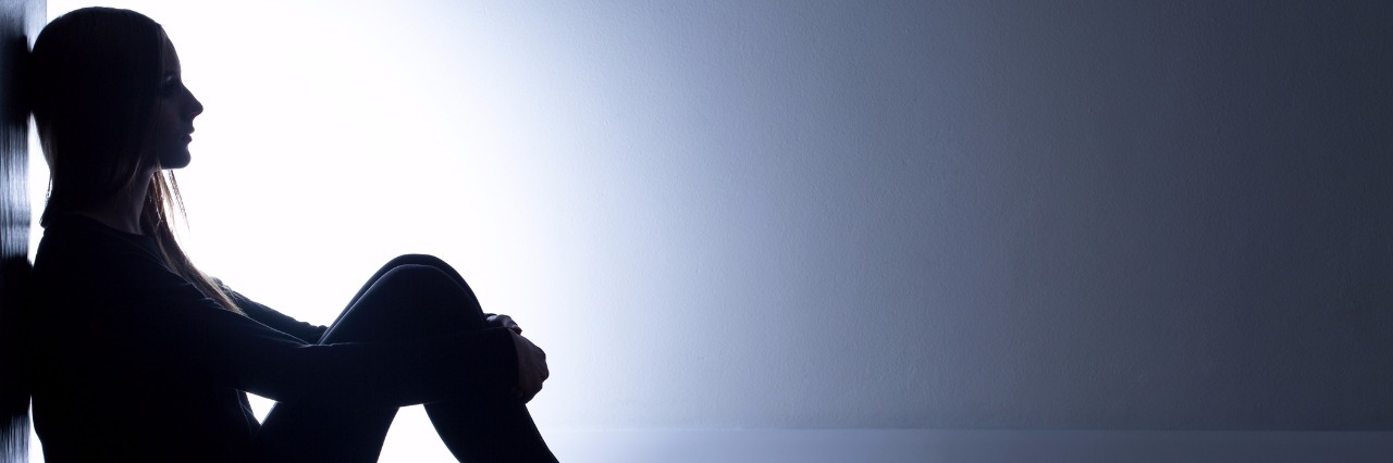 How It Feels When You're Running Out of Treatment Options silhouette of person sitting on floor against wall