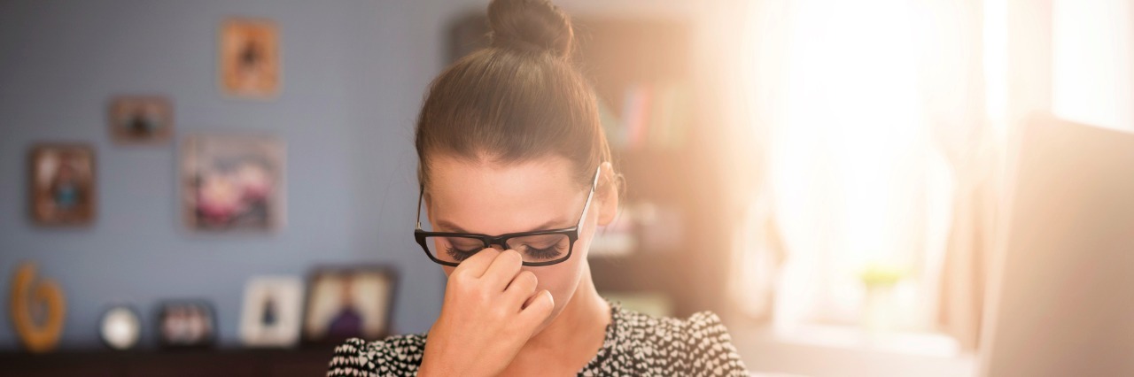 Strong headache at desk with books and papers