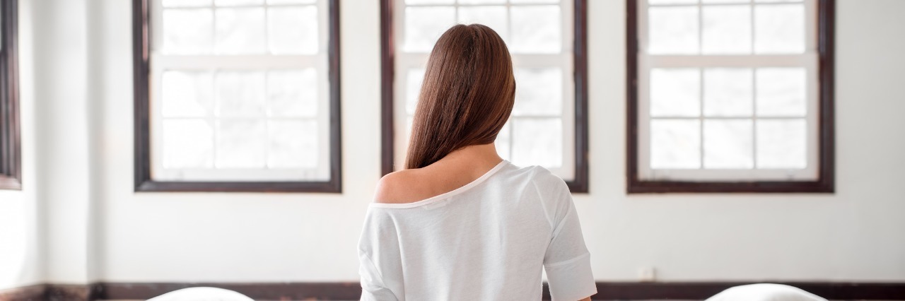 woman sitting cross-legged on the floor looking out the window