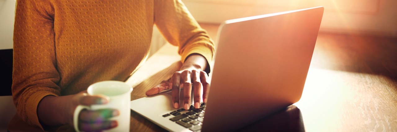 To Those Who Say, 'If You Get Off the Internet, You'll Feel Better' Serious adult female sitting at table holding coffee cup and typing on laptop with light flare coming through window
