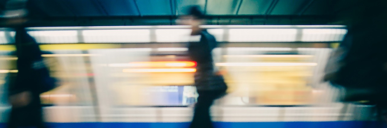 Subway train leaving station. People on platform.