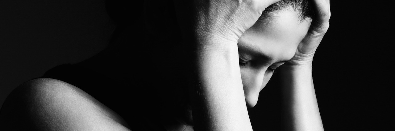 What It Feels Like to Hear Voices in My Head A woman with her head on her hands