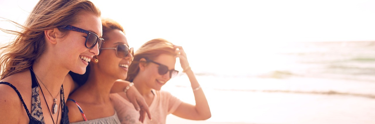 4 Ways to Better Respond to Your Friend With a Chronic Illness Group of happy young women walking on a beach.
