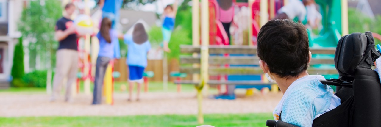 Thanking a Parent Who Helped Encourage My Son With a Disability Little boy in wheelchair watching children play on playground.