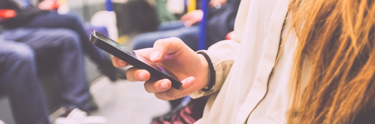 13 Things to Do on Your Phone When You're Feeling Anxious in Public young woman on her phone