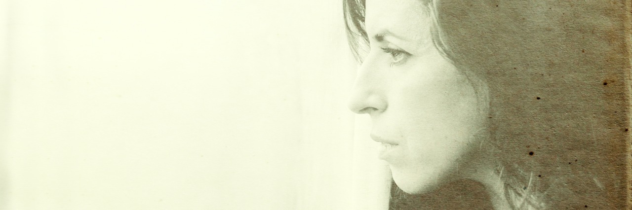 Accepting That I Might Never Get a Diagnosis 35 year old woman stands in front of the window