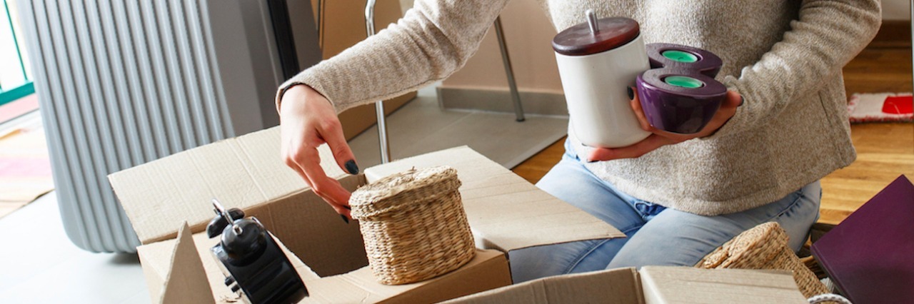 Woman packing and putting items into boxes at home