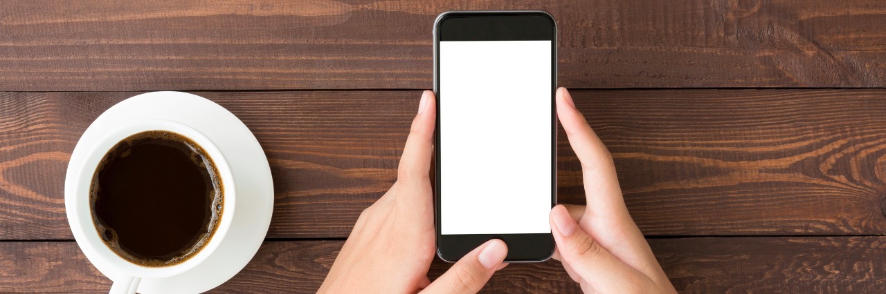 Why I Find 'Life' in My Phone Due to My Chronic Illness phone white screen in woman hand on table top view