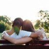 Closeup of two women embracing on a park bench