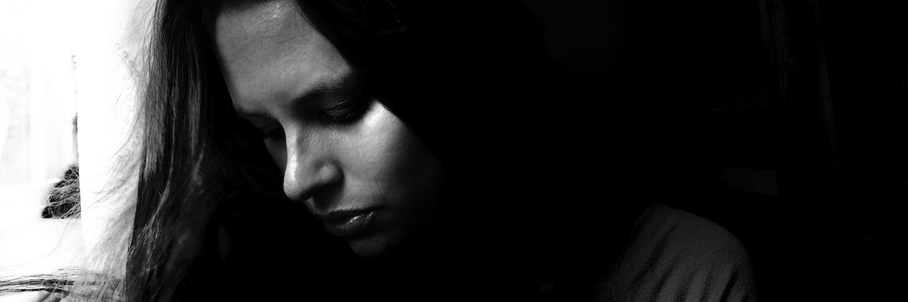 The Lasting Mental Effects Self-Harm Left Me Behind A woman looking down