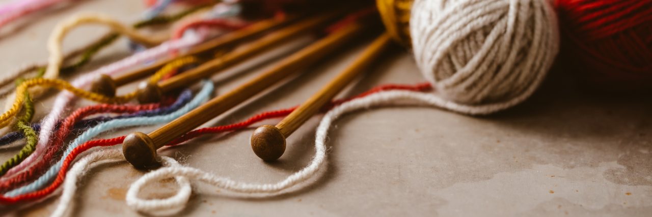 Unravelling Ball of Wool Is a Metaphor for My Depression Close up of assorted yarn and wooden needles
