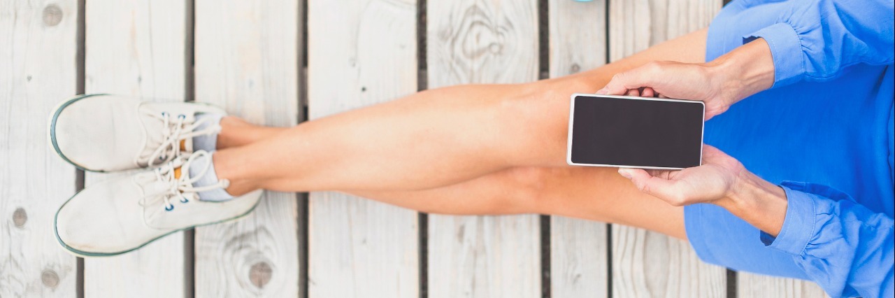 How My Husband's Text Messages Help Me with My IBD woman sitting with phone on lap