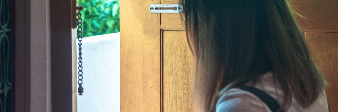 Feeling Anxious When Leaving Home Due to Chronic Illness woman opening her front door to go outside