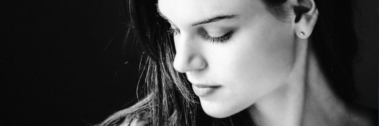 black and white photo of woman with long hair in darkness