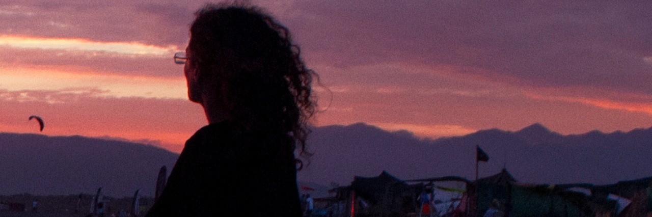 The Fears of a Loss Parent Woman on beach turned toward the sky at sunset