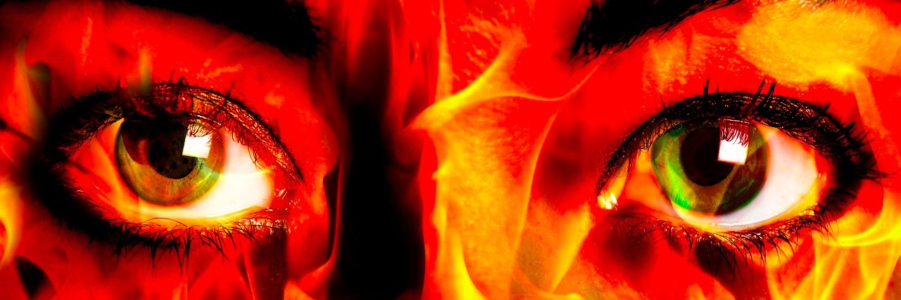close up of woman's eyes with flame pattern over face