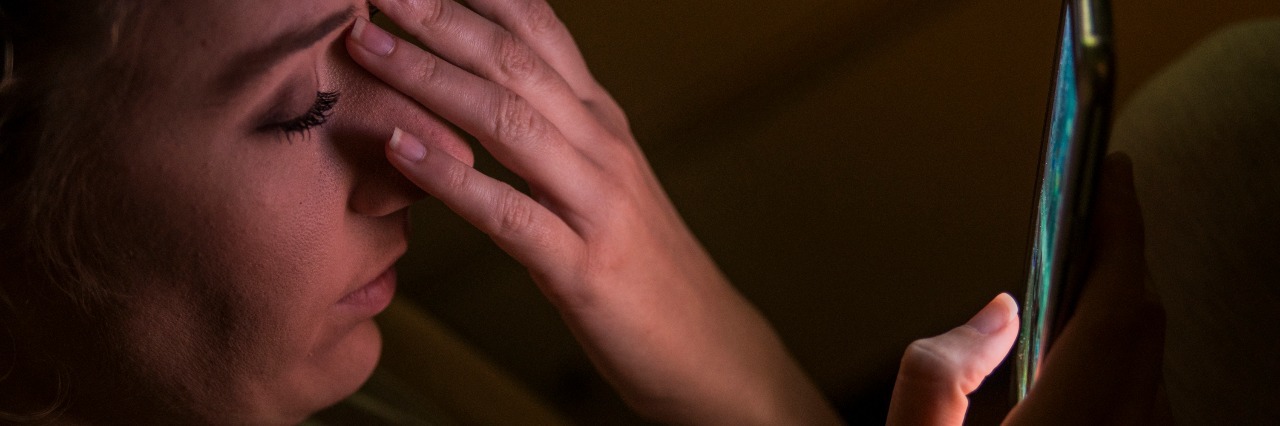 The Pros and Cons of Using Online Therapy App 'Talkspace' Upset woman using phone at night