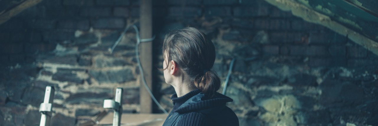 Depression Makes My Mind an Attic: A Poem A young woman is sitting by herself in a derelict loft space
