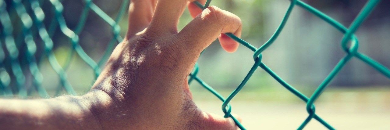 Why I'm Telling the Truth When I Say 'Nothing is Wrong' hand gripping a fence