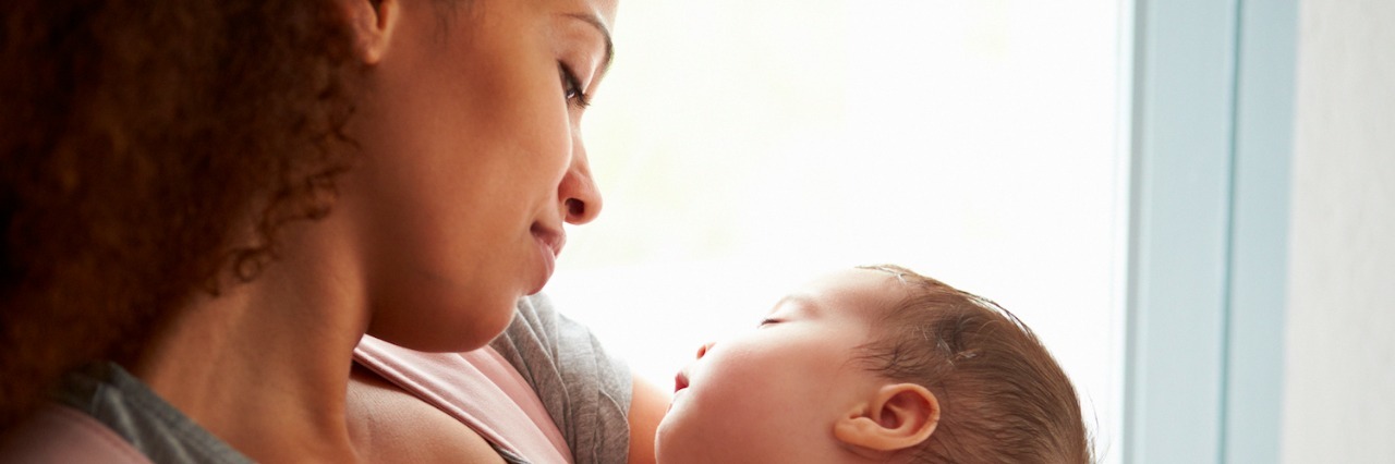 Mother holding baby, looking down at baby