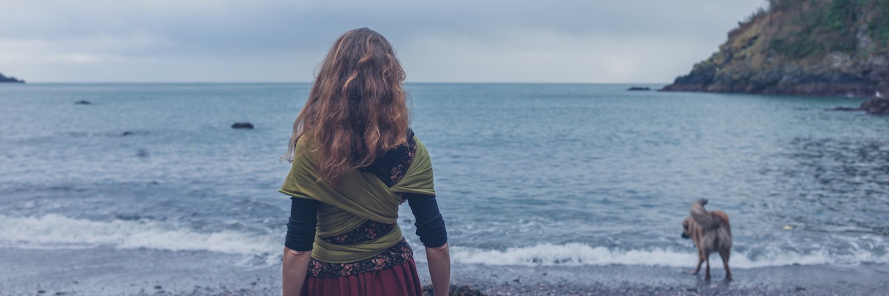 Why I Struggle to Describe What Depression Feels Like A young woman is walking her dog on the beach