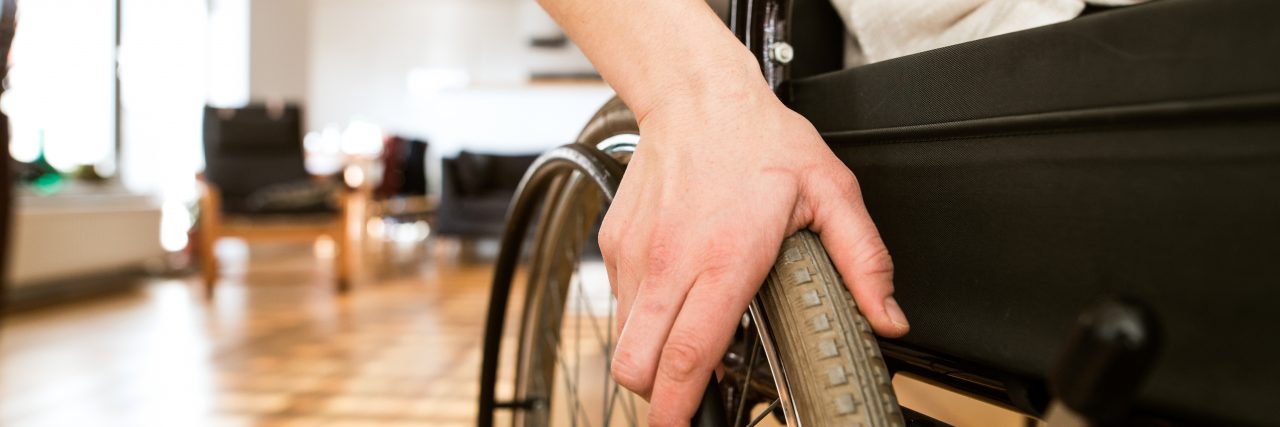 Letter to 'Normal' Americans, From a Woman With a Disability Woman in wheelchair at home in living room.
