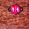 Toilet sign on old brick wall background.