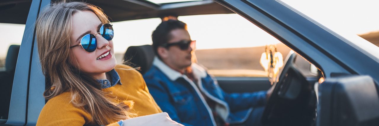 A Letter to the People Who Love Those With Anxiety Young couple on a road trip, in car enjoying ride in sunset